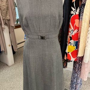 Gray sleeveless dress with buckle at waist.